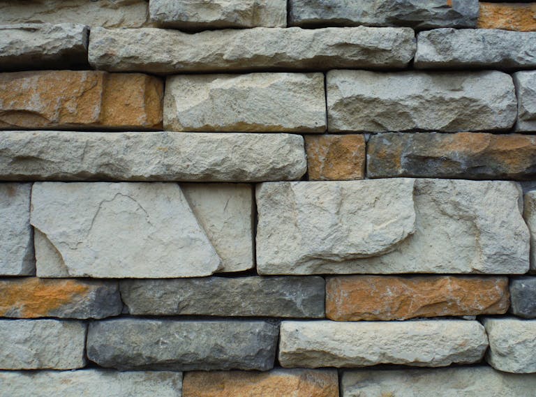 Close-up of a textured stone wall with a variety of natural colors.